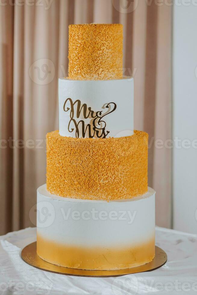 un Boda pastel en un gris estilo, decorado con el letras Sres. y señora., soportes en un pararse. decoración. boda. dulces foto