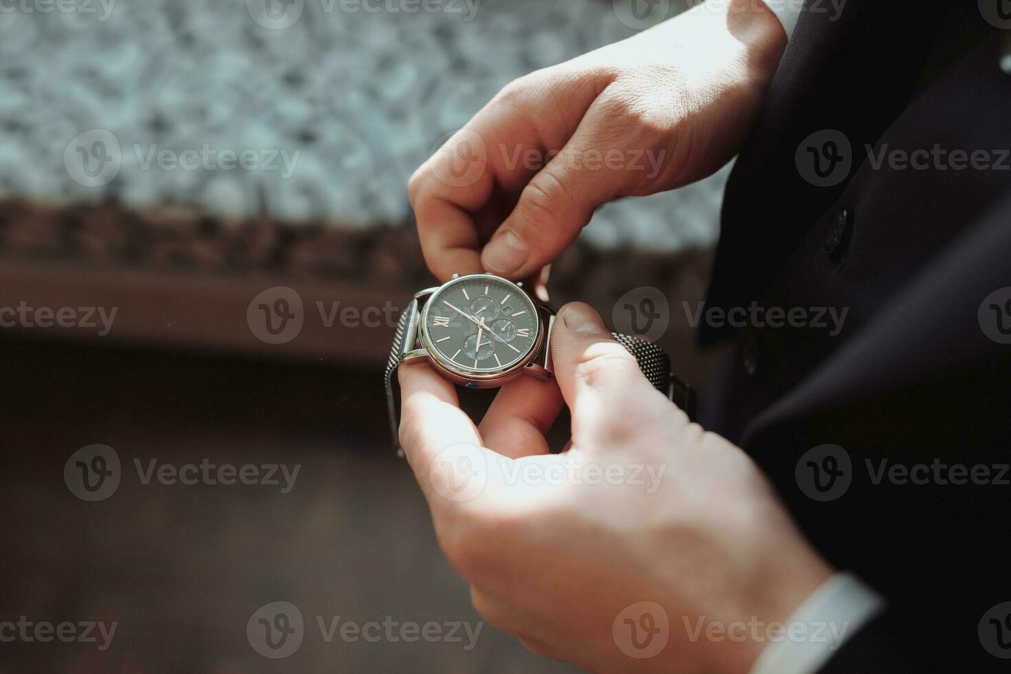 Details. A man in a white shirt puts a watch on his hand. Top view. Daylight. Fashion and style. Business. Men's style photo