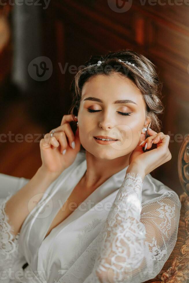 beautiful bride on a retro sofa in a dressing gown with open legs, photo portrait. Wedding hairstyle, light makeup