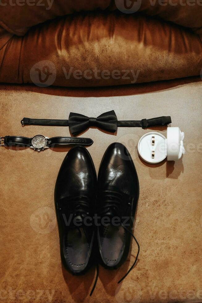 The morning of the groom and details, the details of the groom are dark. men's watch, wedding rings, men's bow tie photo