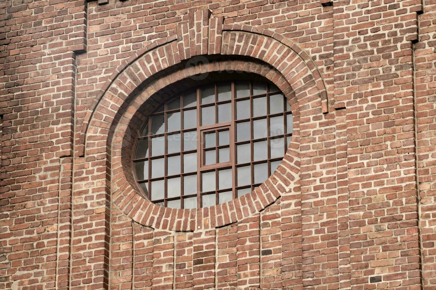 old window in a brick wall of an industrial nearly 100 years old buiding photo