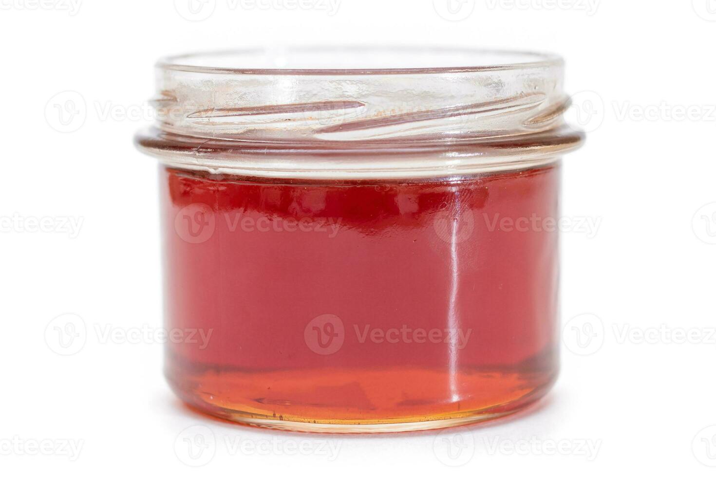 Dark Honey in a Small Glass Jar Isolated on White Background photo