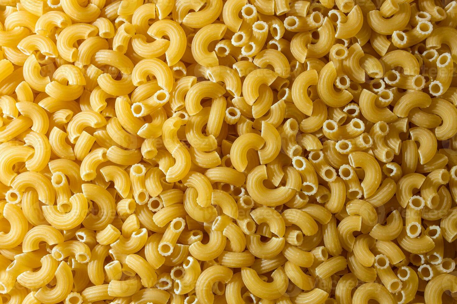 Uncooked Chifferi Rigati Pasta. A Culinary Canvas of Chifferi Rigati, Creating a Lively and Textured Background for Gourmet Cooking. Dry Pasta. Raw Macaroni - Top View, Flat Lay photo