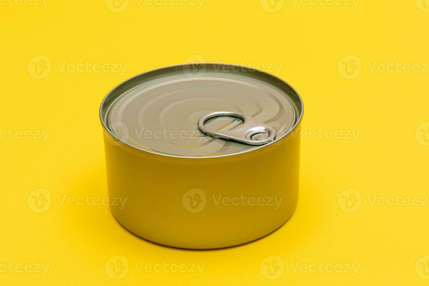 sin abrir estaño lata con blanco borde en amarillo antecedentes. Enlatado alimento. aluminio lata para seguro y largo término almacenamiento de alimento. acero sellado comida almacenamiento envase foto