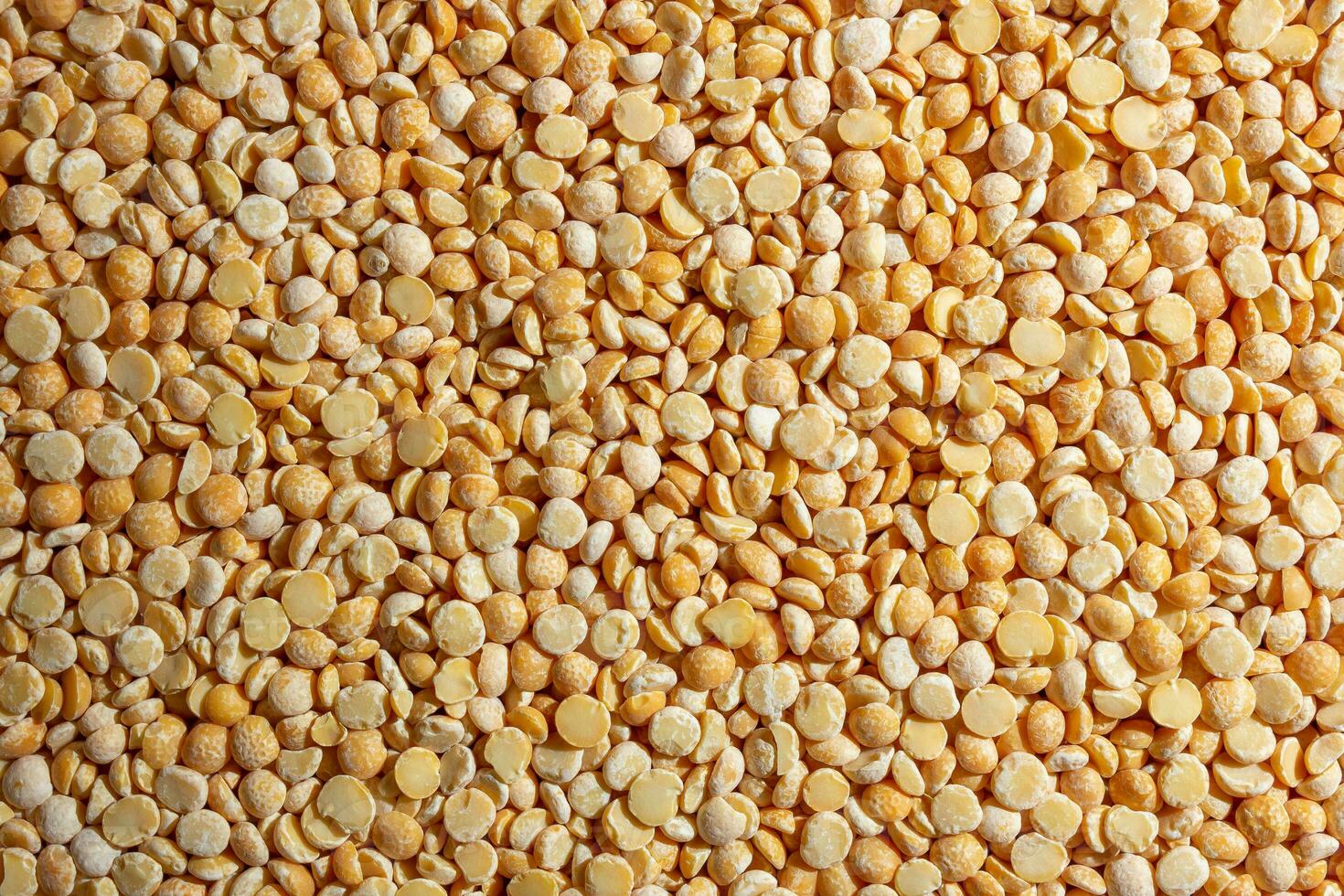 Uncooked Polished Split Peas Background. A Culinary Canvas of Dry Yellow Peas, Creating a Lively and Textured Background for Gourmet Cooking. Scattered Raw Polished Peas. Healthy Eating Ingredients photo