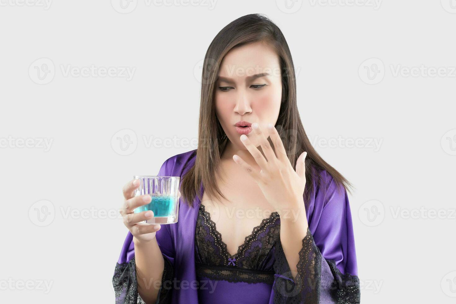 A Woman in purple nightgown feel burn in her mouth because using mouthwash photo