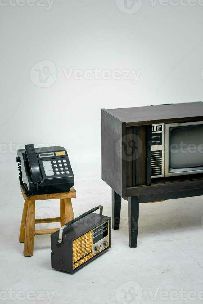 Retro old television with clipping path isolated on white background. TV stand and blank screen, with vintage radio and telephone, technology. photo