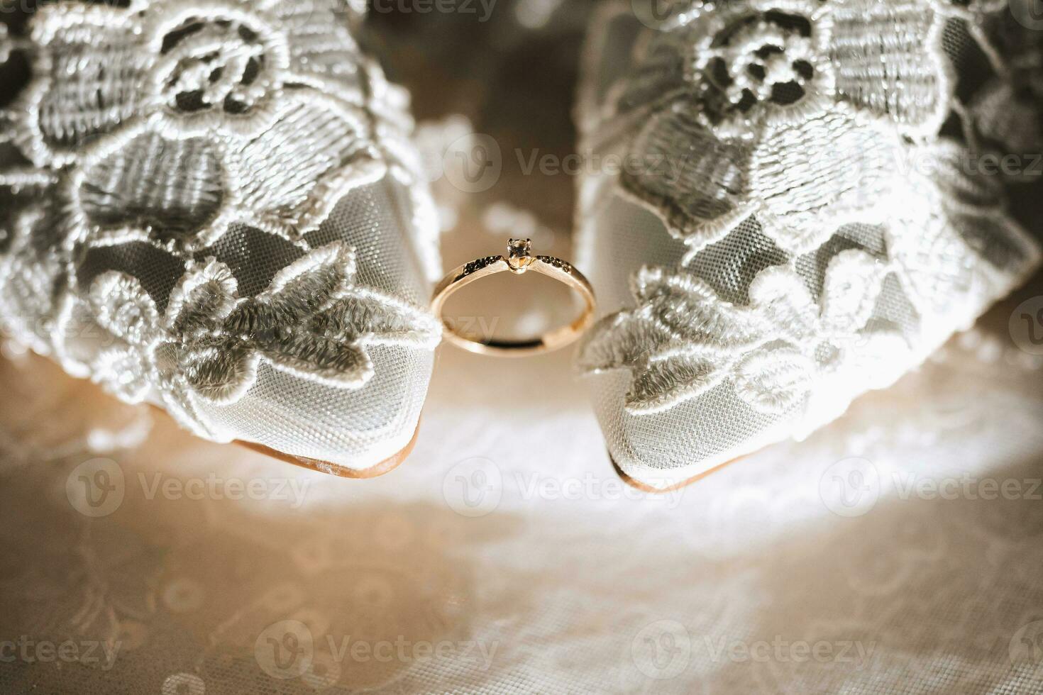 wedding accessories in light colors, shoes, a wedding ring are decoratively arranged in a wonderful backlight photo