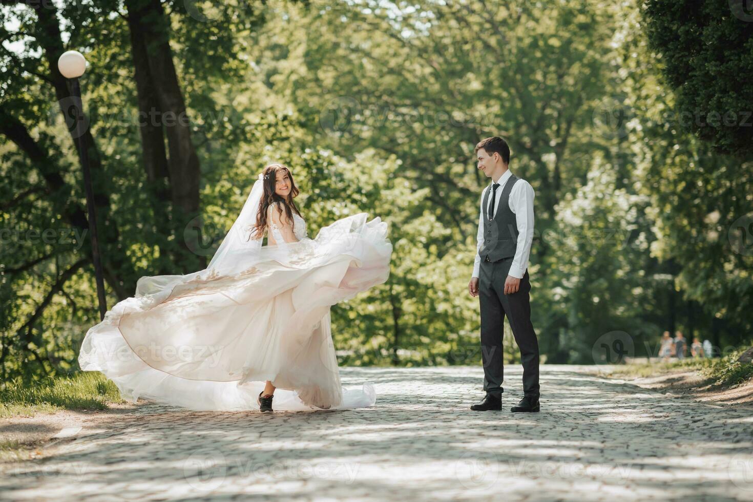 novio y novia en el jardín. primavera Boda en el parque. contento Boda Pareja corriendo en el parque. el novia es dando vueltas con su vestido. elegante y hermosa. foto desde el atrás. princesa vestido.