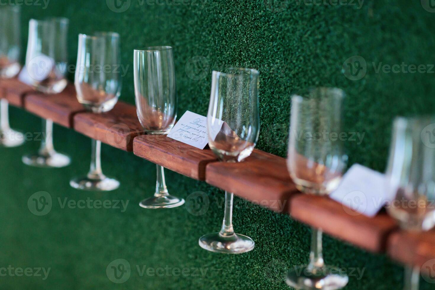 Stand for glasses. A luxurious wedding ceremony. Romantic wedding ceremony. Champagne glasses on a green background. Wedding details photo
