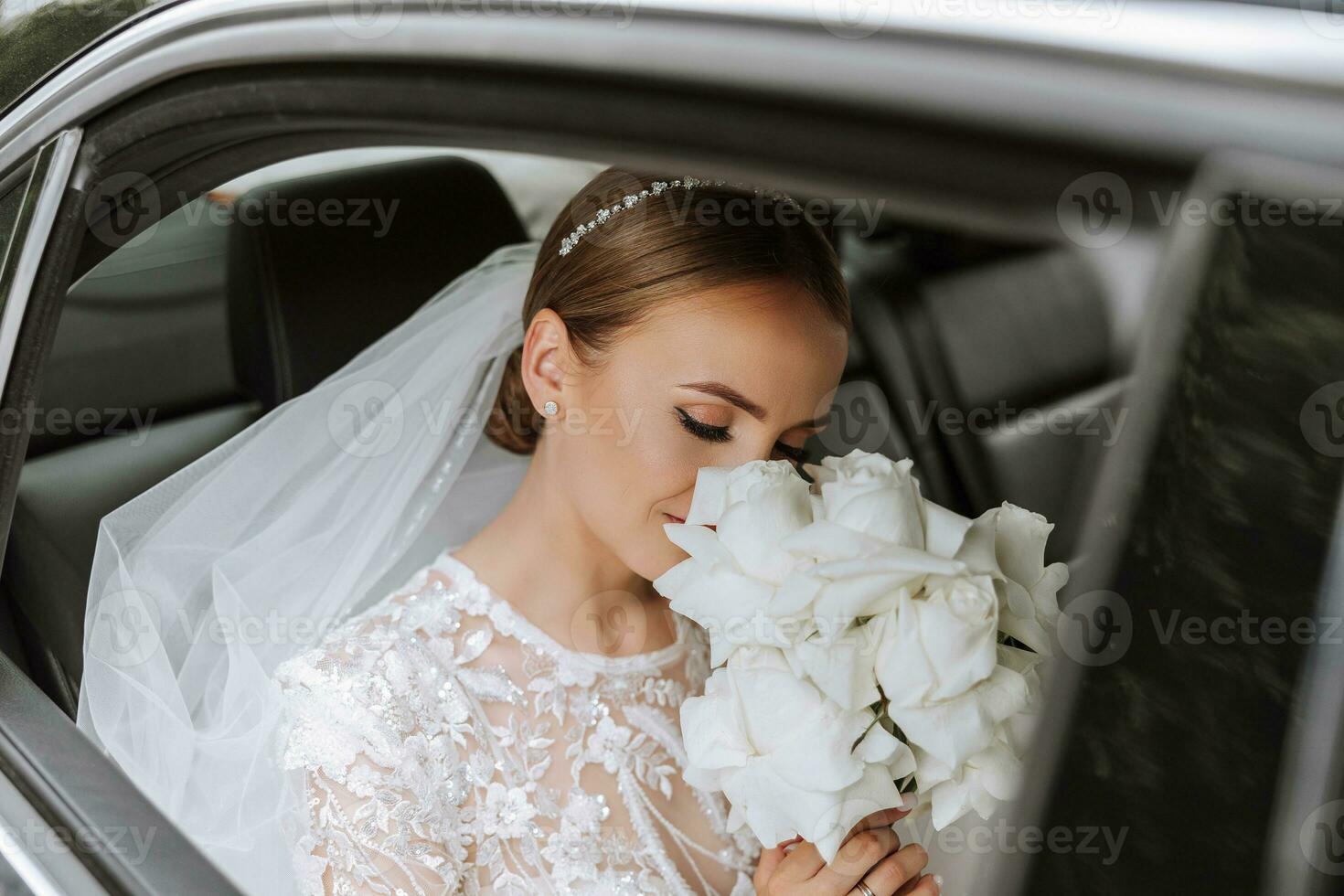 Bride smelling bouquet. Portrait of a beautiful bride with a wedding bouquet. Blonde girl with curly hair and fashion makeup. photo