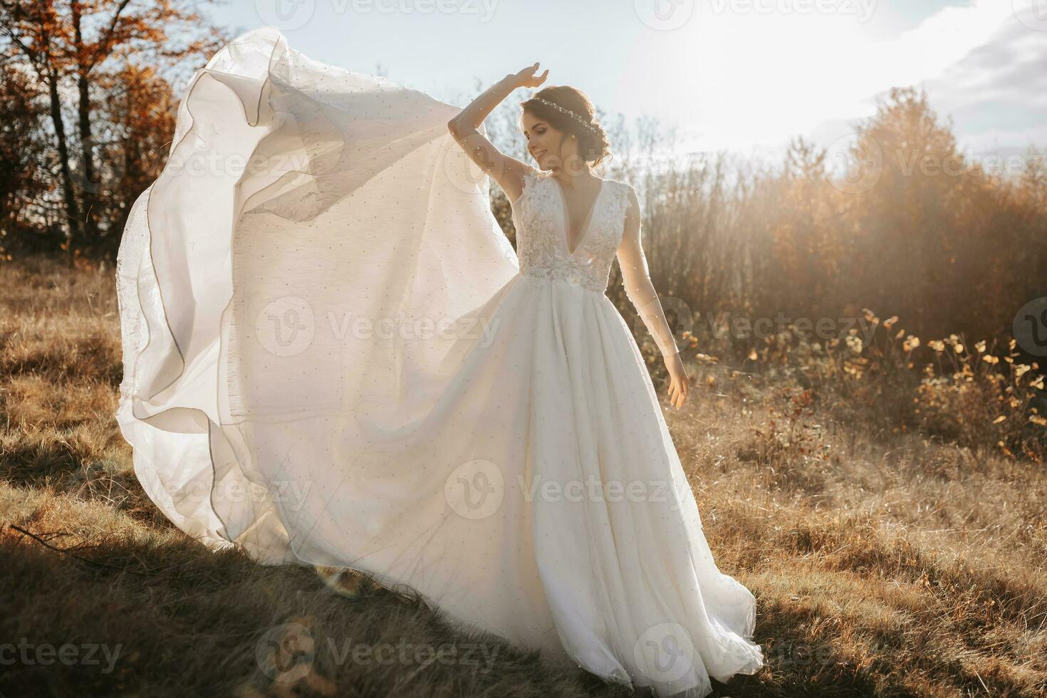 Wedding photo. The bride and groom are walking in the forest. The bride throws up her long dress beautifully. Couple in love. Autumn wedding. photo