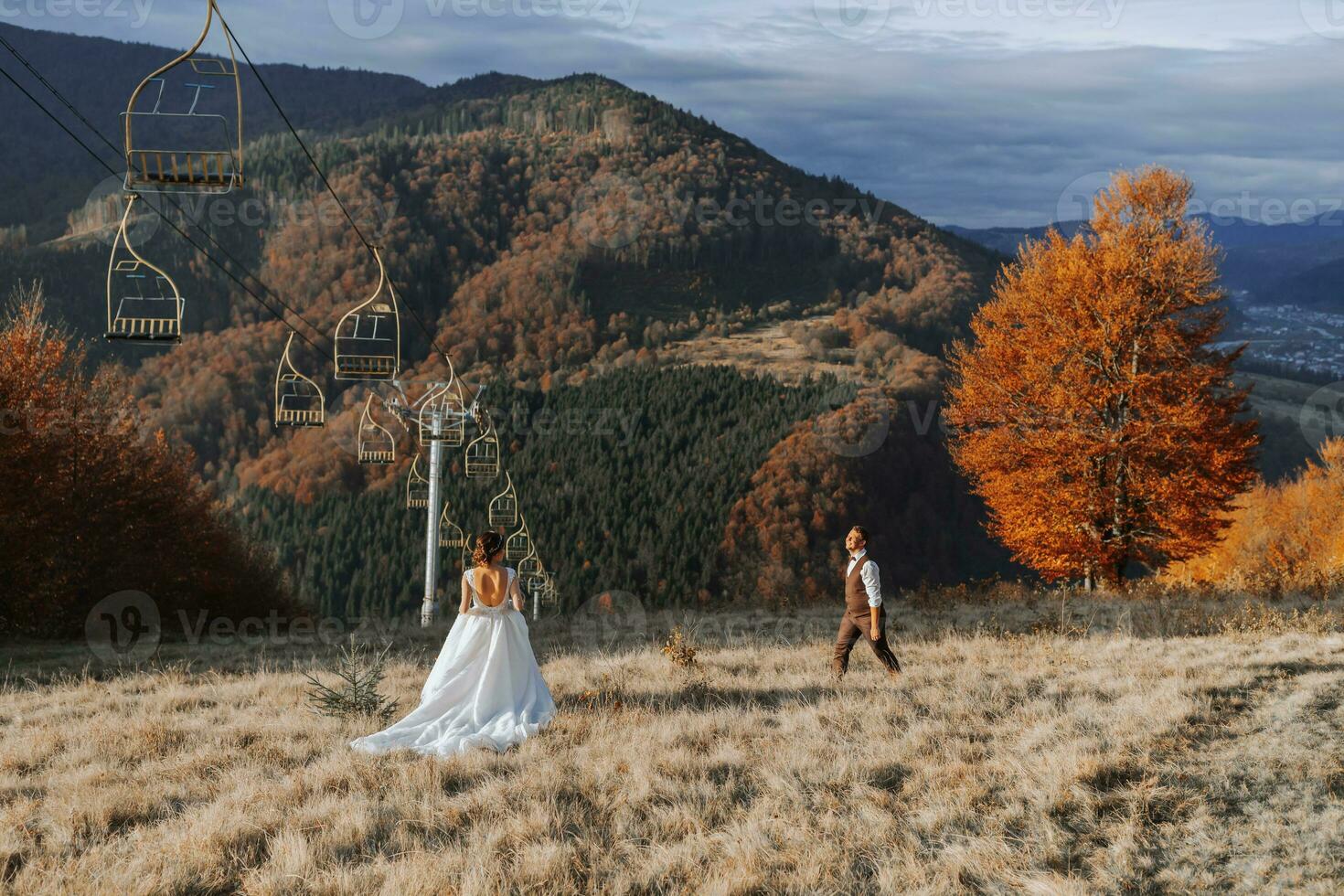 A couple in love in the mountains. Wedding in the mountains. Newlyweds have fun against the background of mountains and enjoy the view. photo