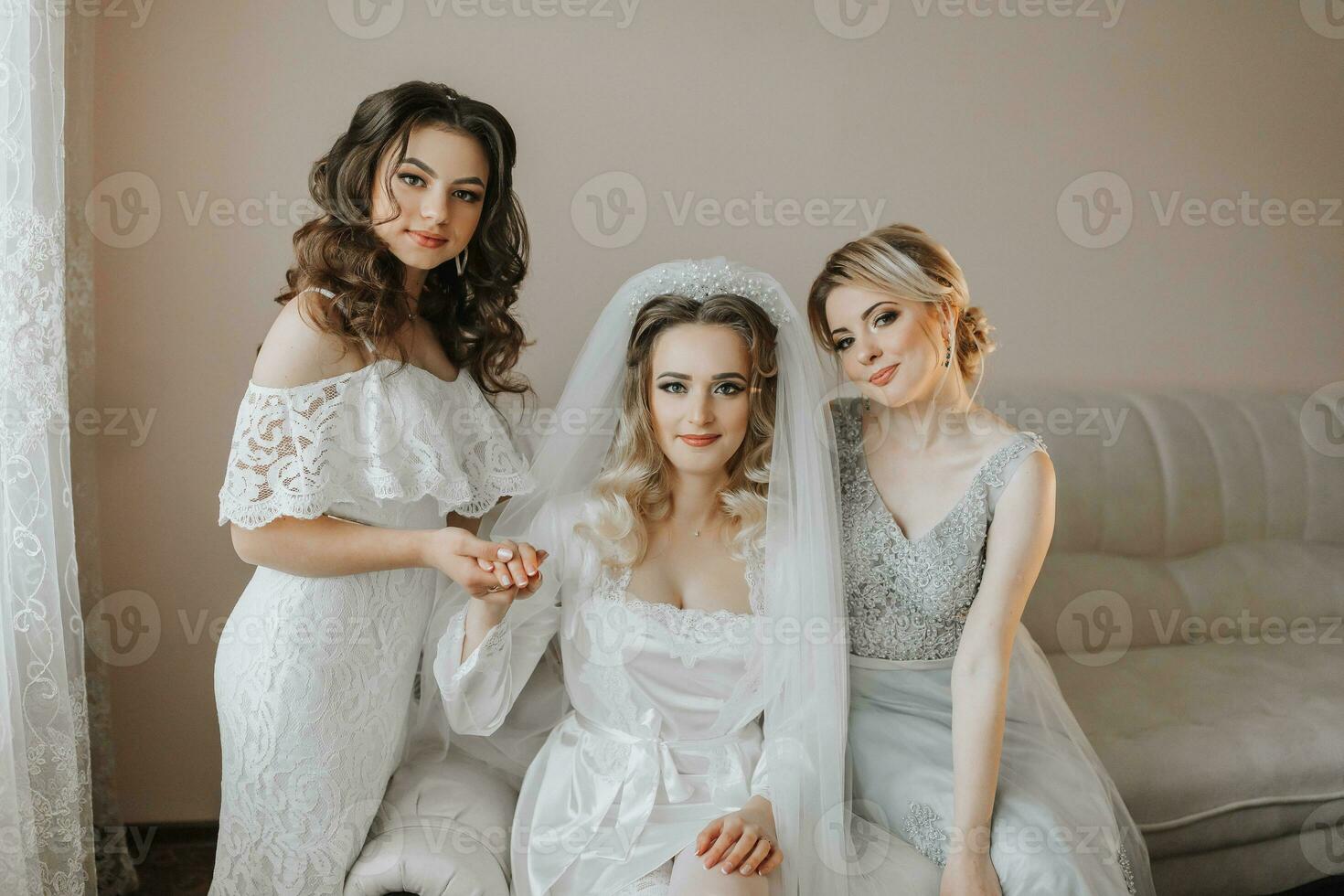 The bridesmaids are looking at the camera. The bride and her fun friends celebrate the bachelorette party in different dresses. Bride and friends in the room photo