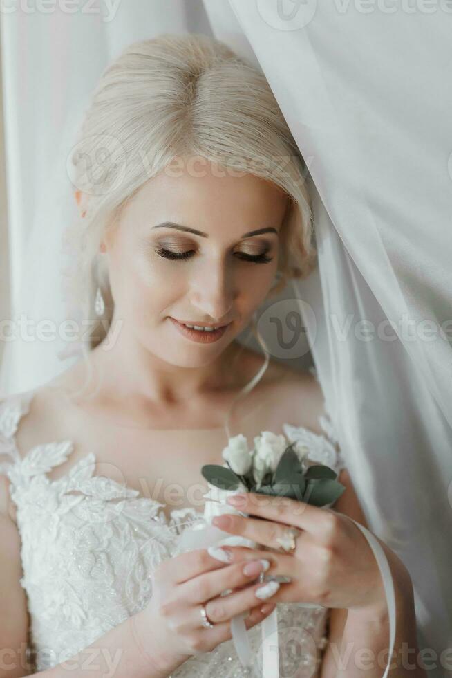 hermosa rubia novia retrato, participación Cordon de zapato en mano Boda maquillaje peinado, maravilloso joven mujer en blanco vestir a hogar. serie foto