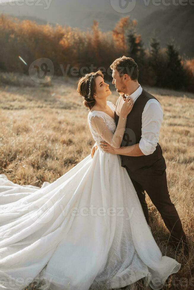 Happy wedding couple posing over beautiful landscape in the mountains photo