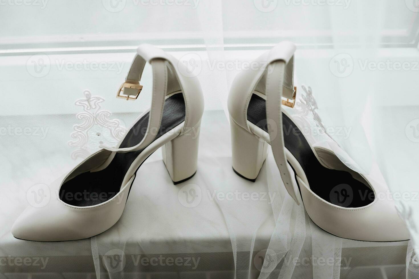 White elegant shoes. A pair of classic white shoes standing on a window sill on a white background. Fashion. Style. Wedding photo