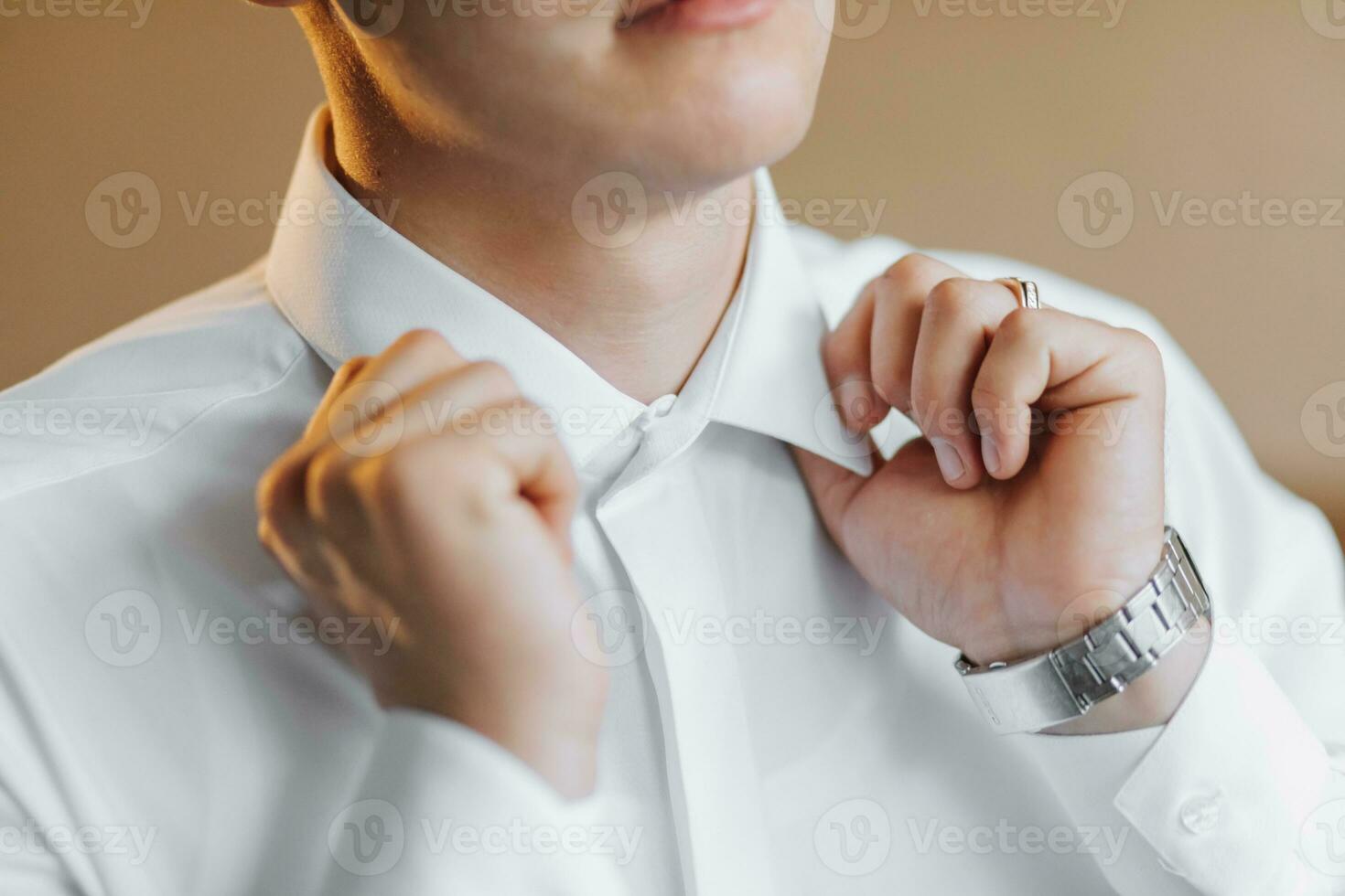 Mañana de el novio y detalles, blanco camisa, bueno luz, joven hombre, elegante novio consiguiendo vestido, consiguiendo Listo para el Boda ceremonia. de cerca de masculino manos foto