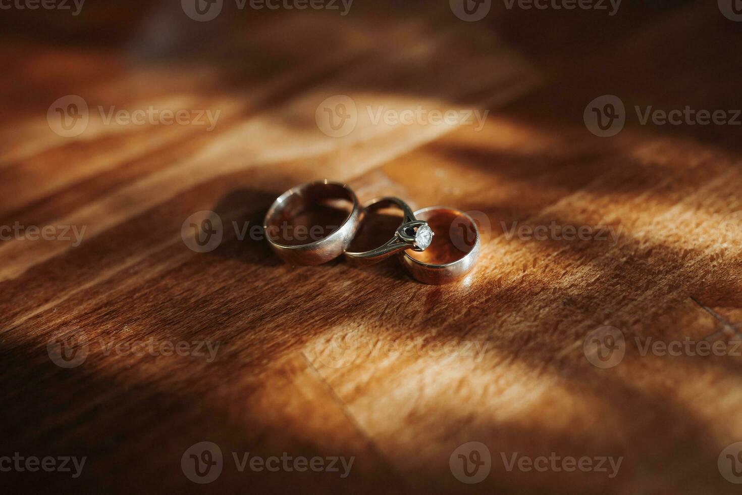 Classic wedding rings on a wood texture background. A beautiful photo with details of the wedding. Wedding day. Contour light. Shadows and light