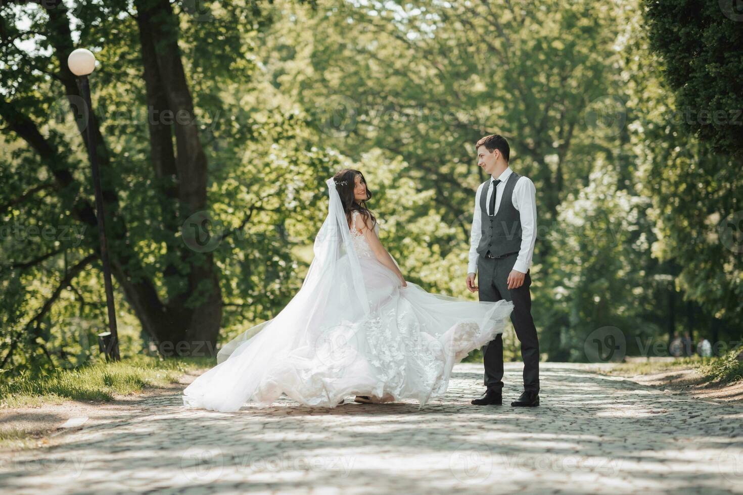 novio y novia en el jardín. primavera Boda en el parque. contento Boda Pareja corriendo en el parque. el novia es dando vueltas con su vestido. elegante y hermosa. foto desde el atrás. princesa vestido.