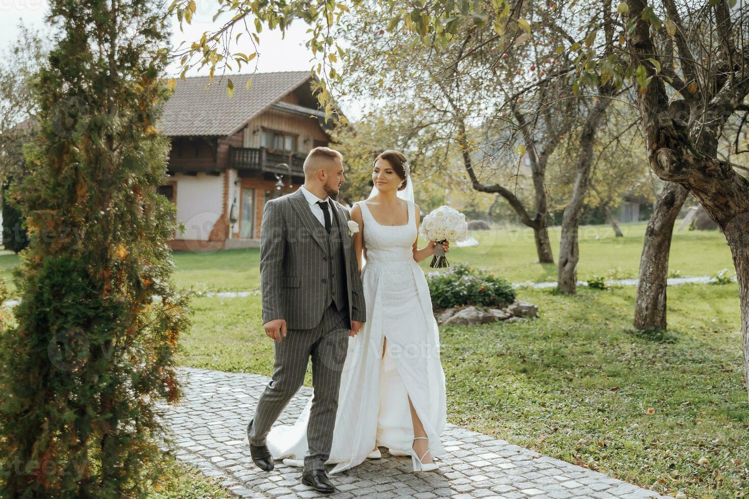 Stylish young brides, happy on their day, enjoy each other. They are walking in the spring park. Spring wedding. Natural makeup photo