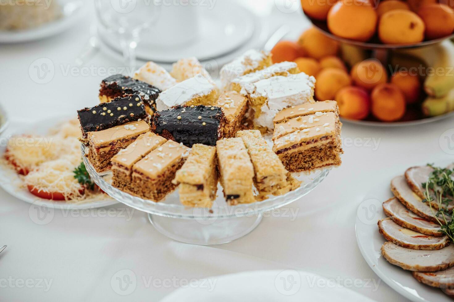 solemn banquet. a buffet table with a lot of delicious snacks. Desserts on a white tablecloth. Cheese snacks. preparation for the celebration photo