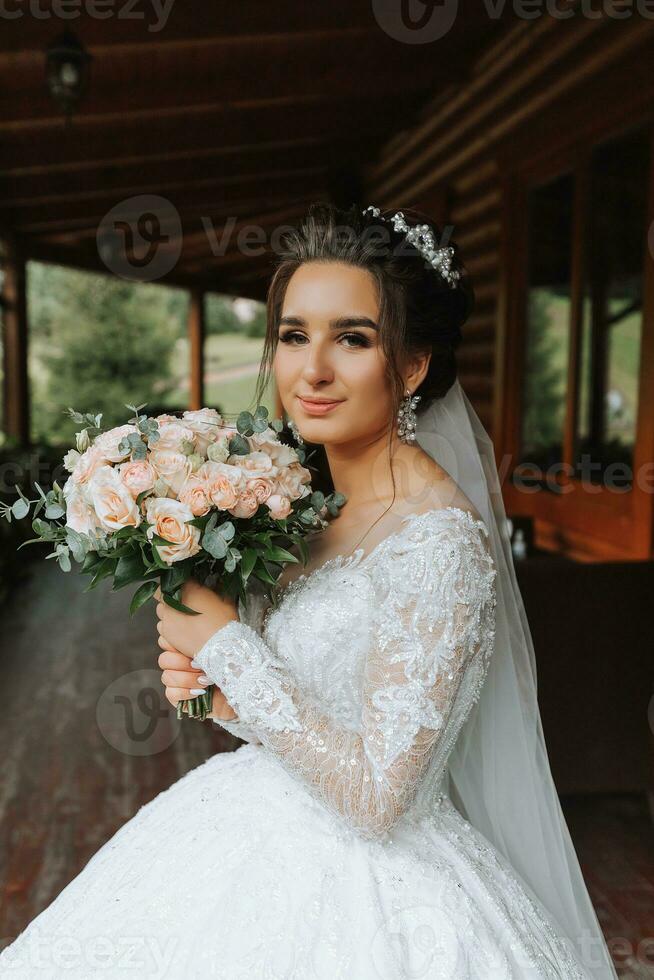 The bride is holding a beautiful wedding bouquet of white and pink roses. portrait of the bride photo