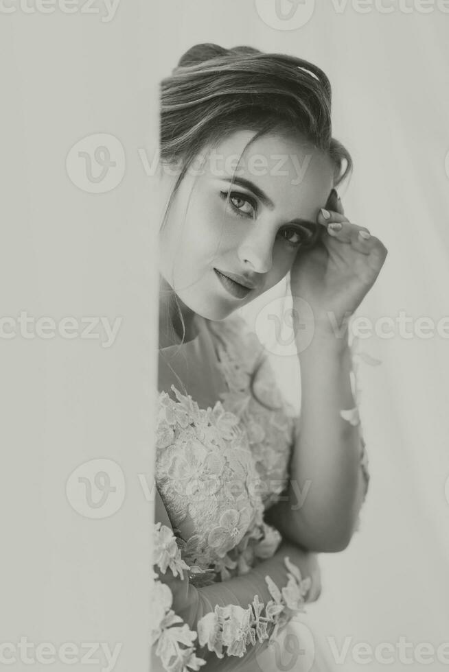 hermosa novia. Boda peinado - en un blanco antecedentes. de cerca retrato de un joven maravilloso novia. boda. retrato de un hermosa novia envuelto en un velo foto