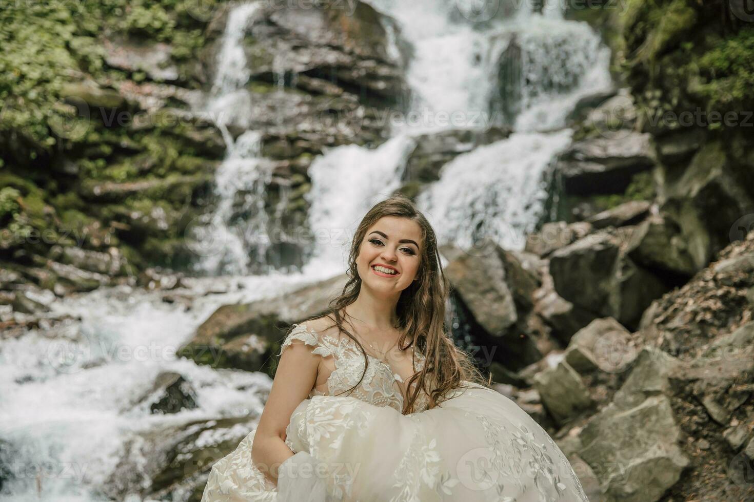 retrato de un contento novia con Rizado pelo cerca un cascada. novia y novio. Boda foto sesión en naturaleza. foto sesión en el bosque de el novia y novio.