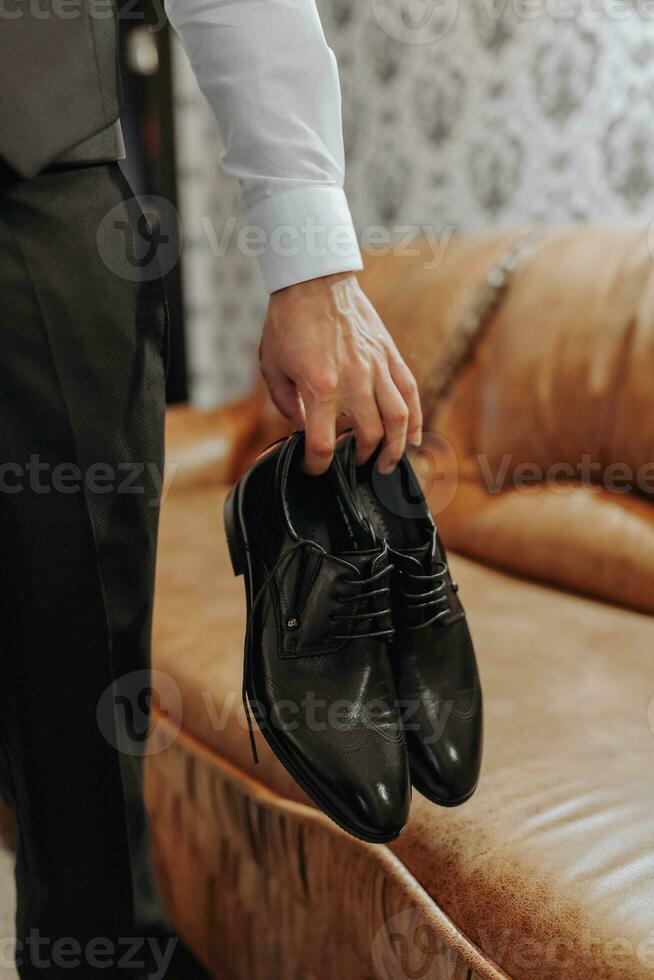 The stylish bridegroom dresses, prepares for the wedding ceremony. Large portrait. Wonderful interior in the morning light. The groom's morning photo