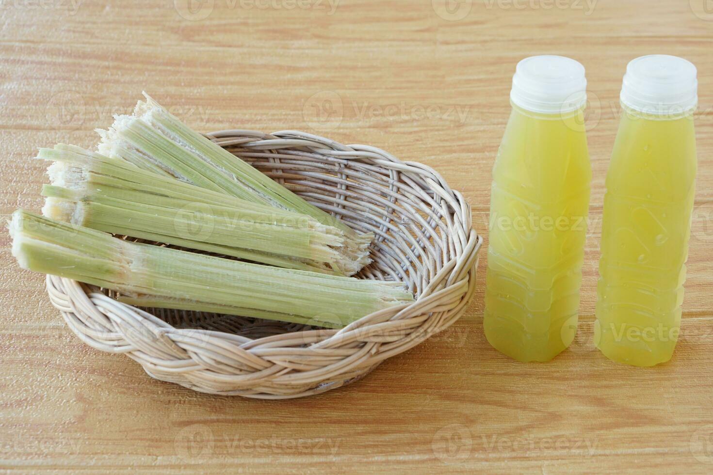 Closeup bottles of fresh sugar cane juice, put on basket. Concept, healthy natural beverage made from agriculture crop. Homemade drinks, has medicinal and herbal properties photo