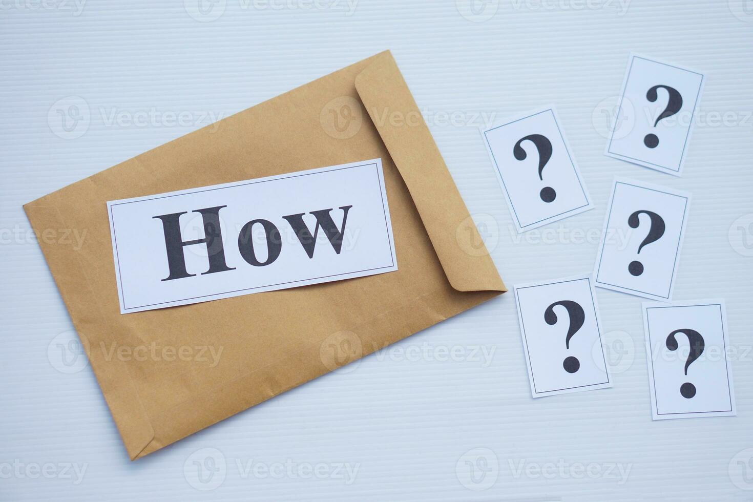 Word cards with question word How on brown envelope and cards of question marks. Concept. Teaching aid. Education materials for teach WH- question. Asking questions. photo