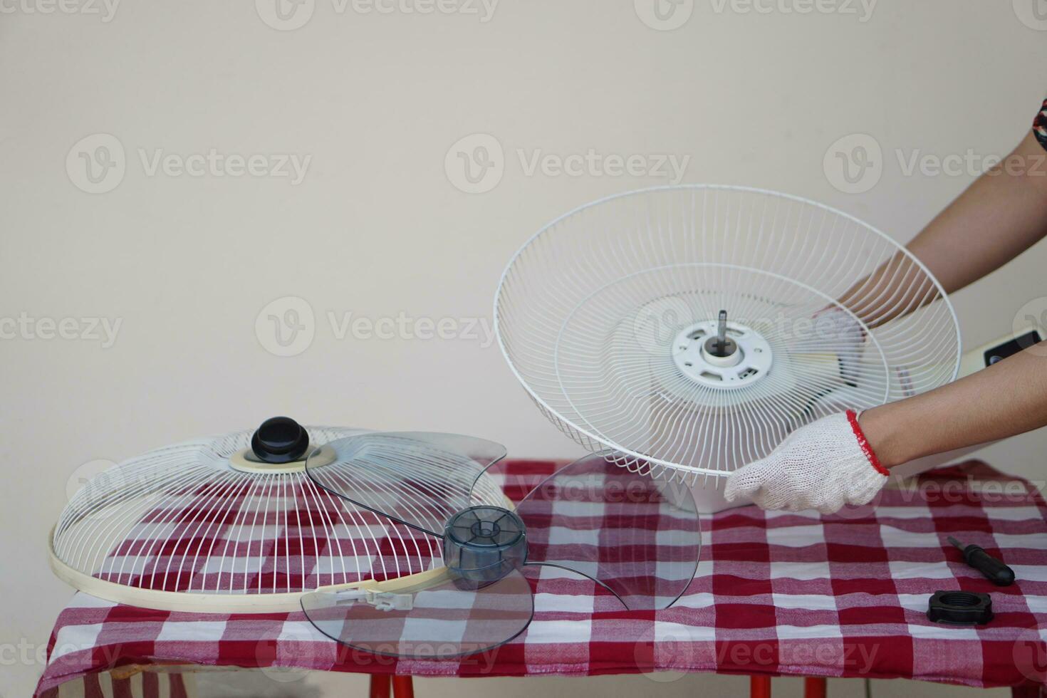 Close up mechanic hands holds parts of electric fan to repair.Concept , Appliance maintenance and repair. Check and repair for safety using in daily life. photo