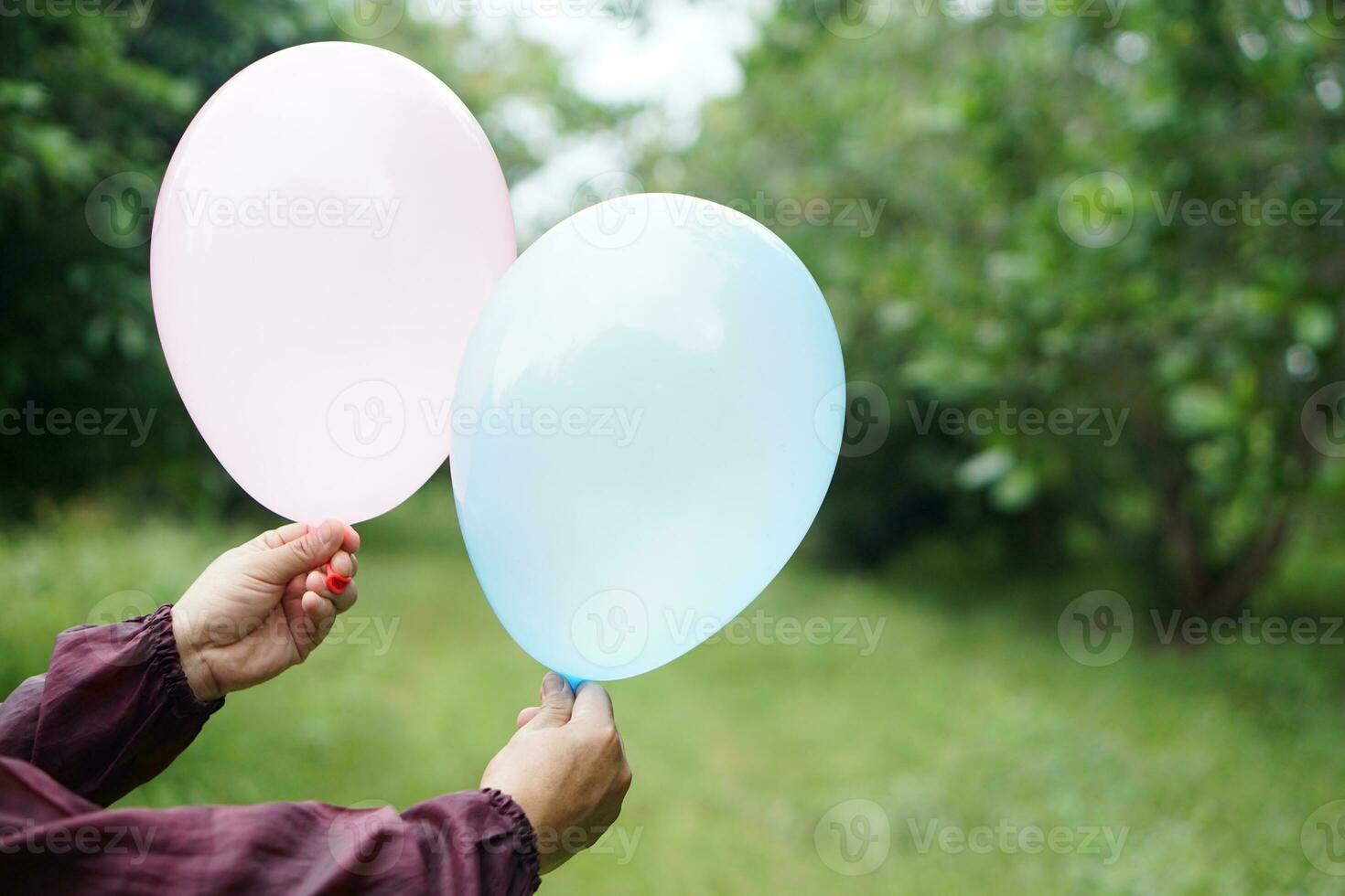 Close up hands hold balloons in the park. Concept, prepare balloon for playing games as a toy, decorate party or celebration. Recreation or leisure activity. Fun and happy time. photo