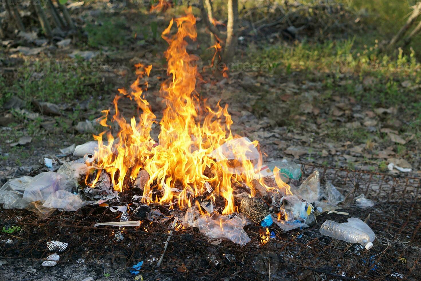 Fire burning pile of garbage. Concept, Incineration of household waste, paper, cardboard, food scraps, plastic, twigs and other waste that causes air pollution. Trash management photo