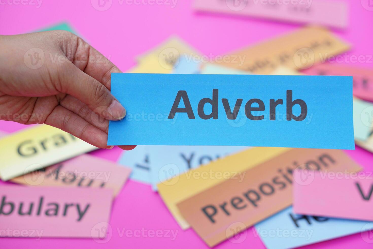 Close up hand hold blue word card with text Adverb. Concept, English language grammar teaching. Using word card to create for playing educational fun games. Part of speech photo