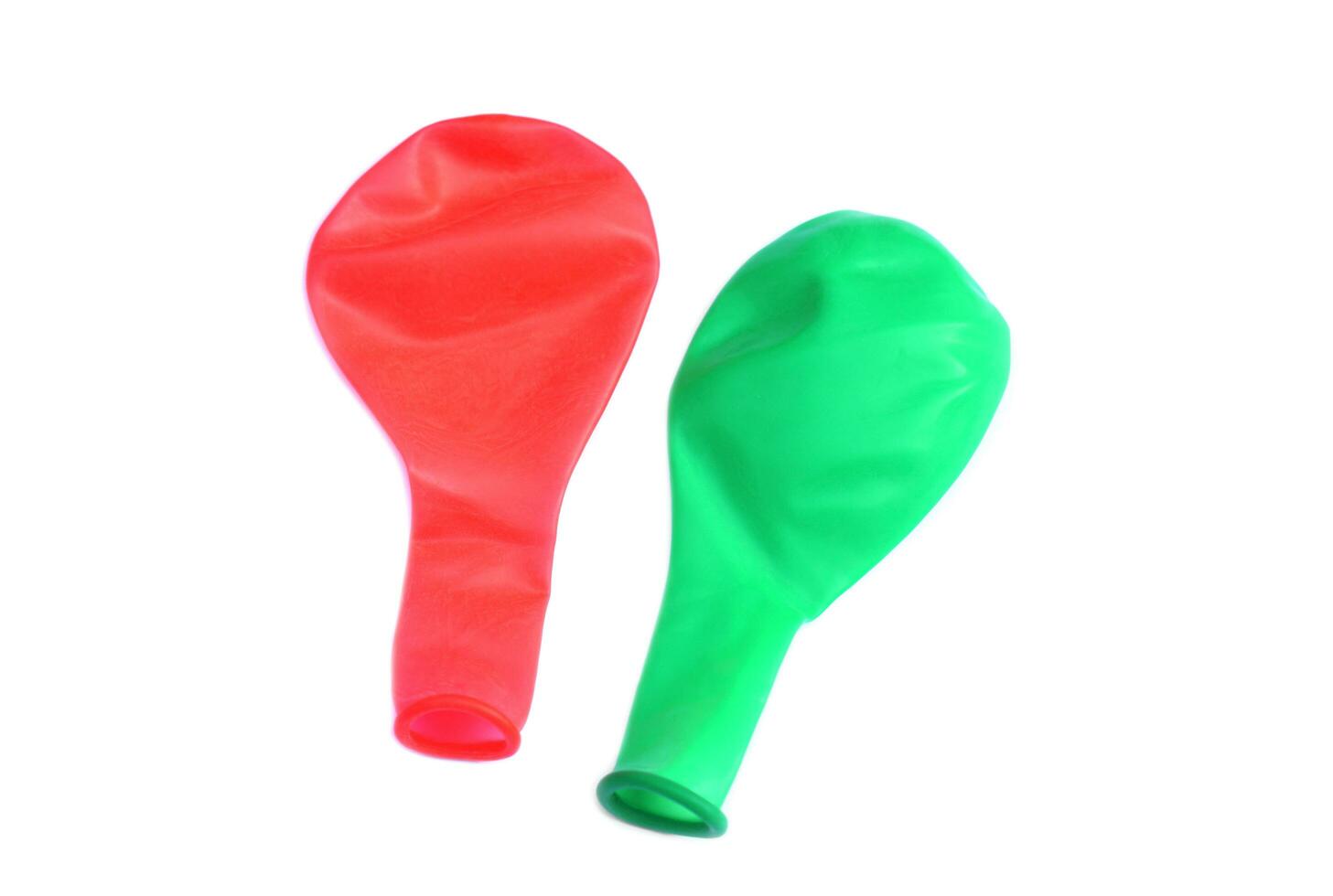 Red and green balloons on white background, flat, no air inside. Concept, equipment for decoration party, celebration,toy for playing games or doing science experiment. photo