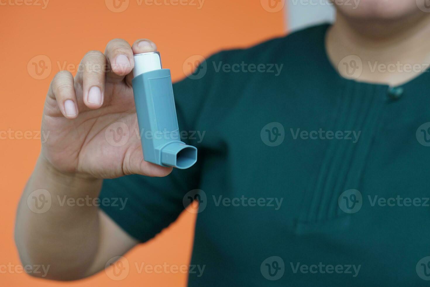 Close up patient's hand holds asthma inhaler. Concept, health care. Pharmaceutical products for treatment symptoms of asthma or COPD. Use under prescription. Health care device at home. photo
