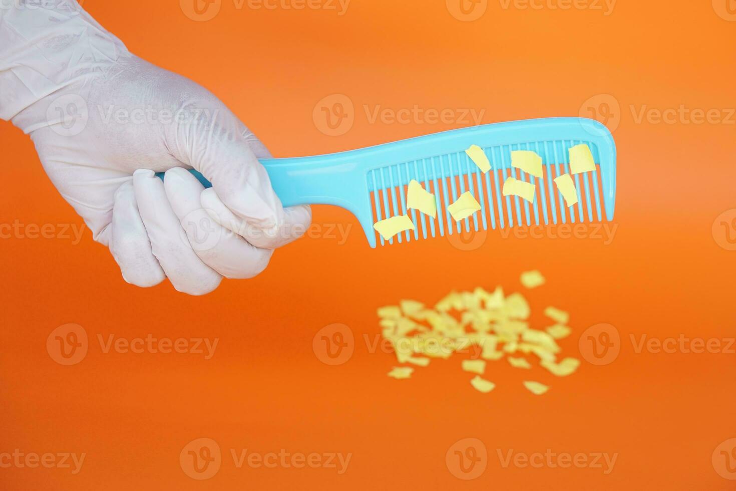 Comb and small pieces of paper. Equipment, prepared to do experiment about static electricity. Orange background. Concept, Science lesson, fun and easy experiment. Education. Teaching aids. photo
