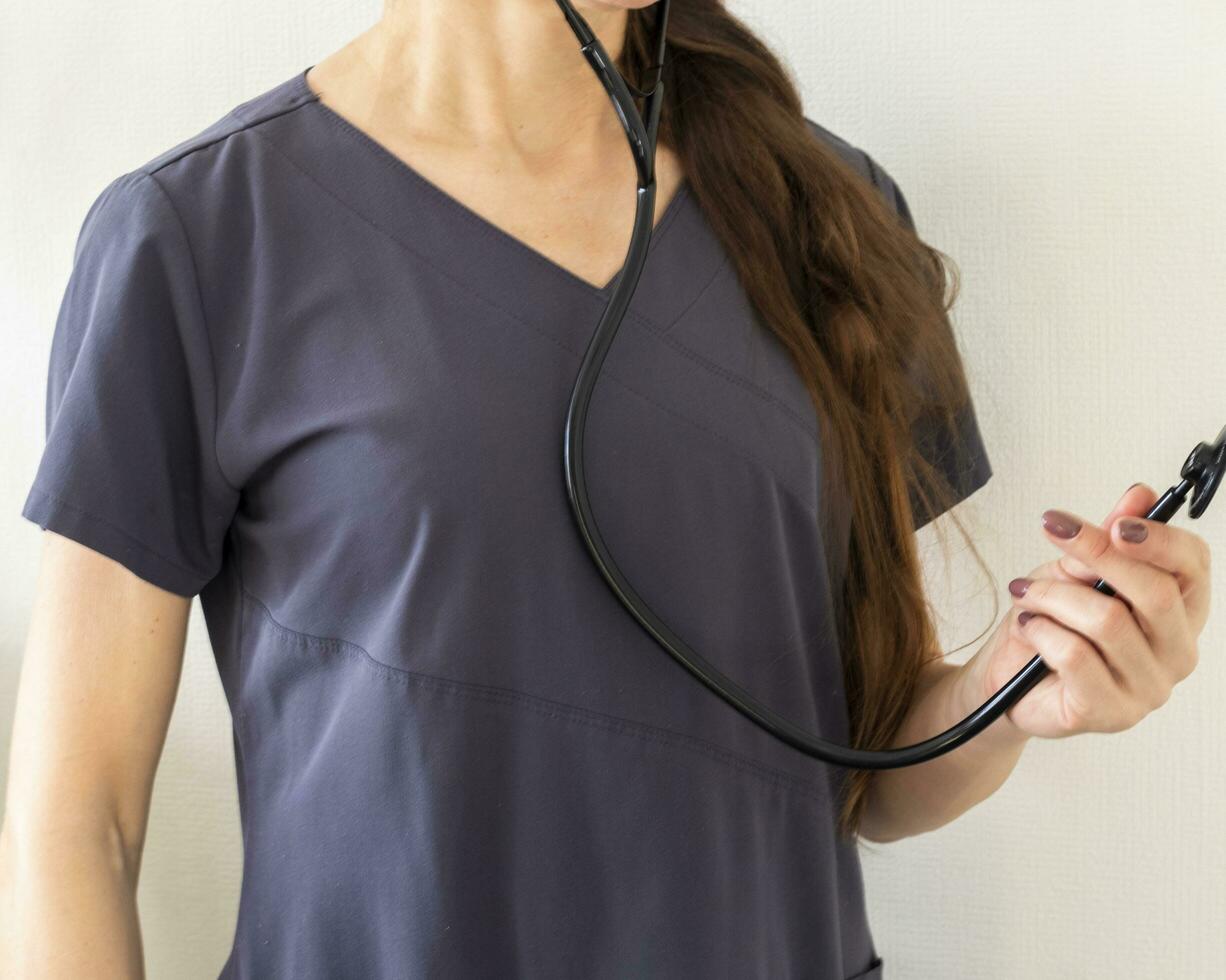Shot of the female doctor in uniform against the white wall. Healthcare photo