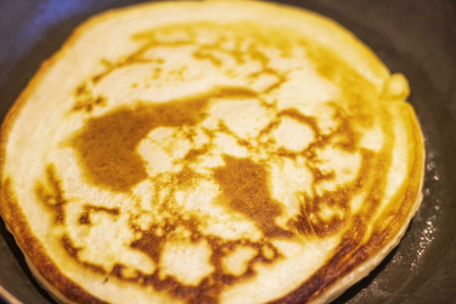 cerca arriba Disparo de un panqueques siendo horneado en el cocina. comida foto