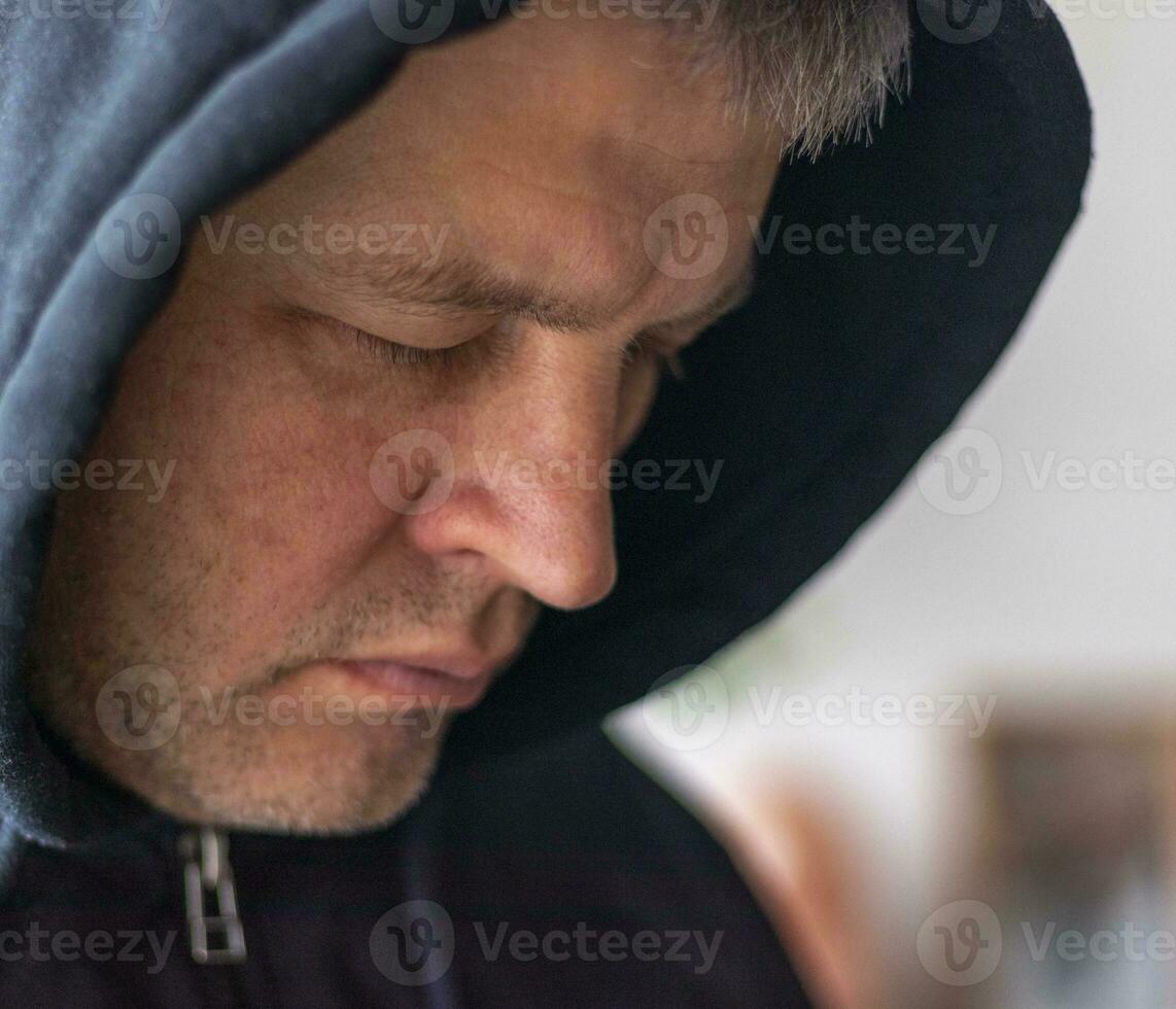 Man looked like hacker in a hood looking at the screen. People photo