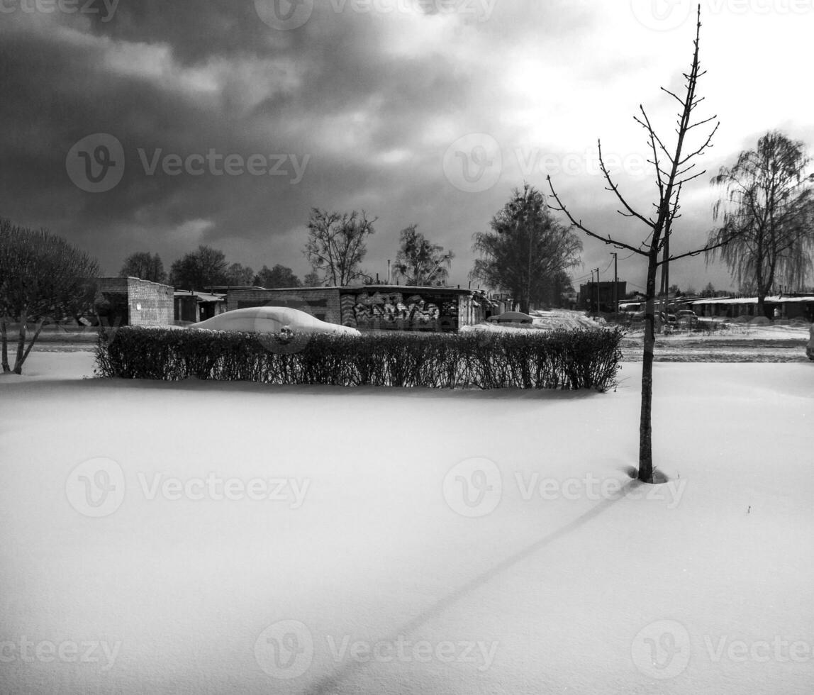 Landscape shot of the street on the winter day. Car covered in the snow. Season photo