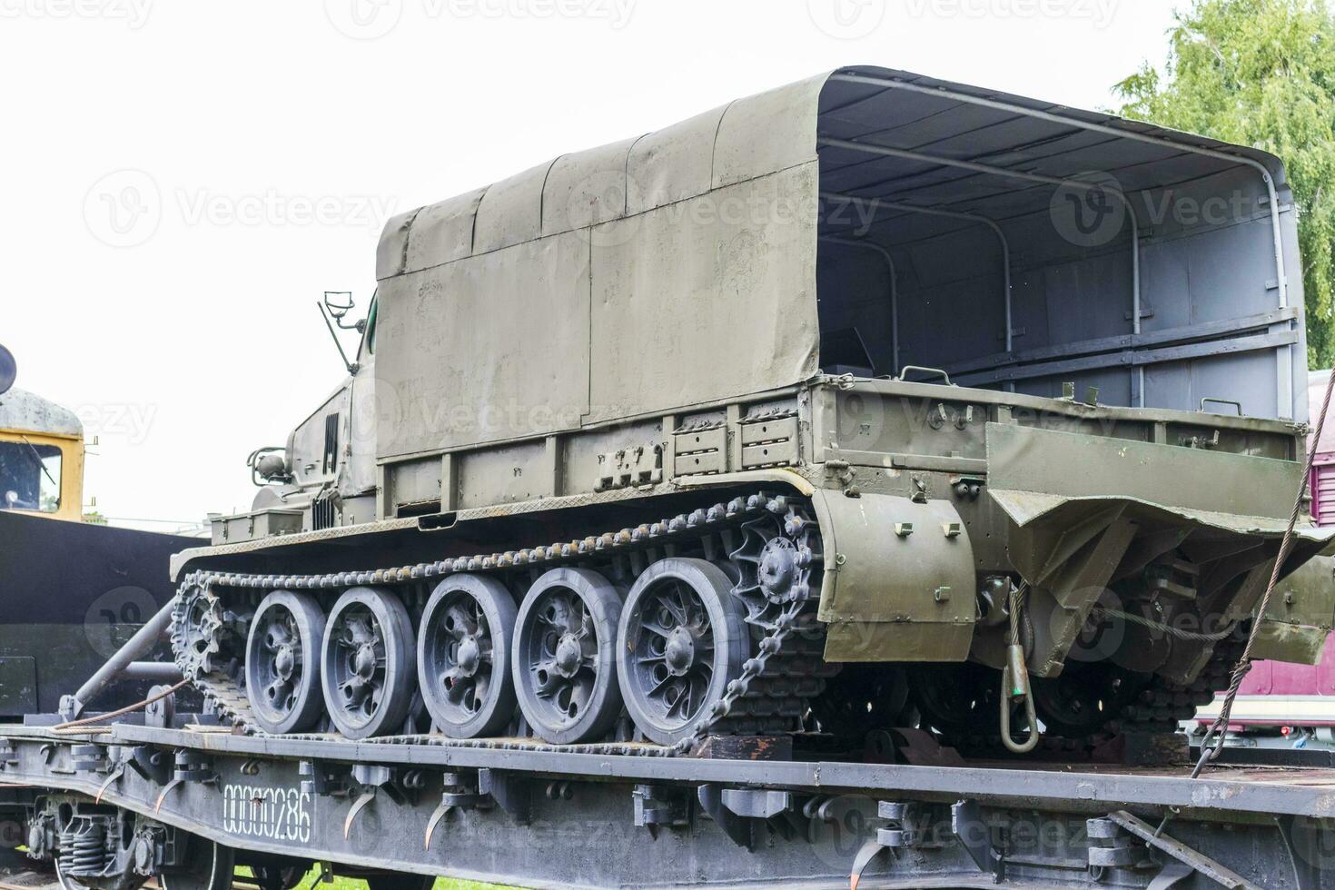 Shot of the vintage old construction train transporting military trucked vehicle. War photo