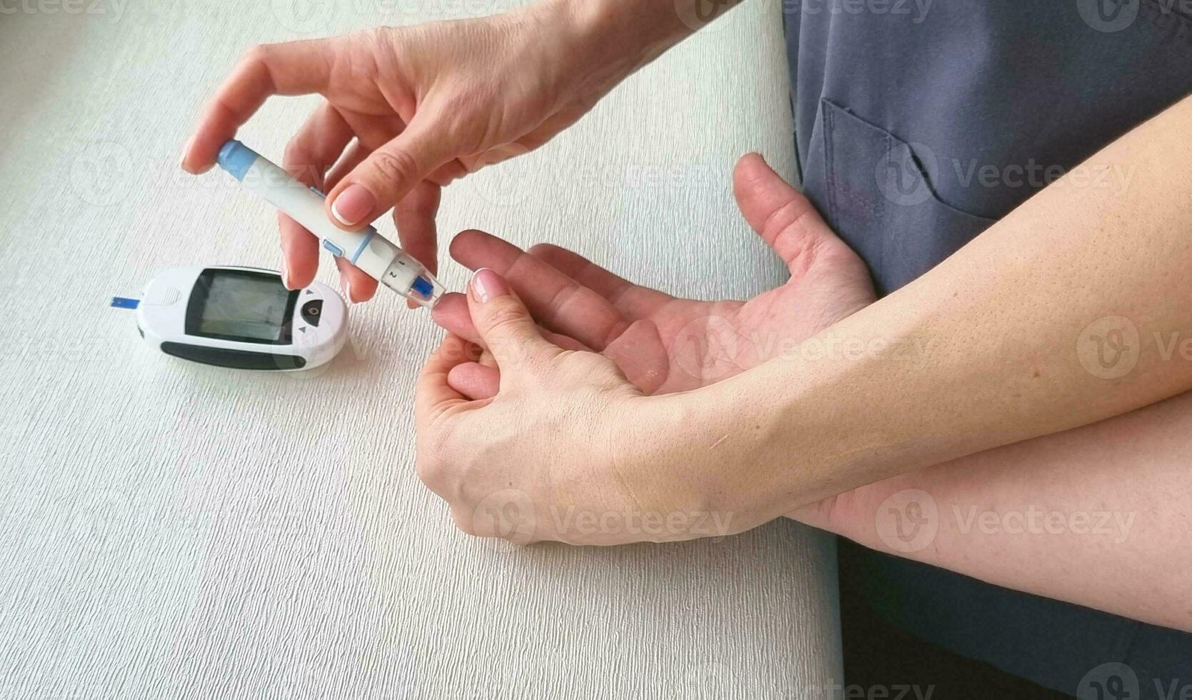 Close up shot of the glucometr instrument on the white surface. Nurse helping patient to check sugar level. Healthcare photo