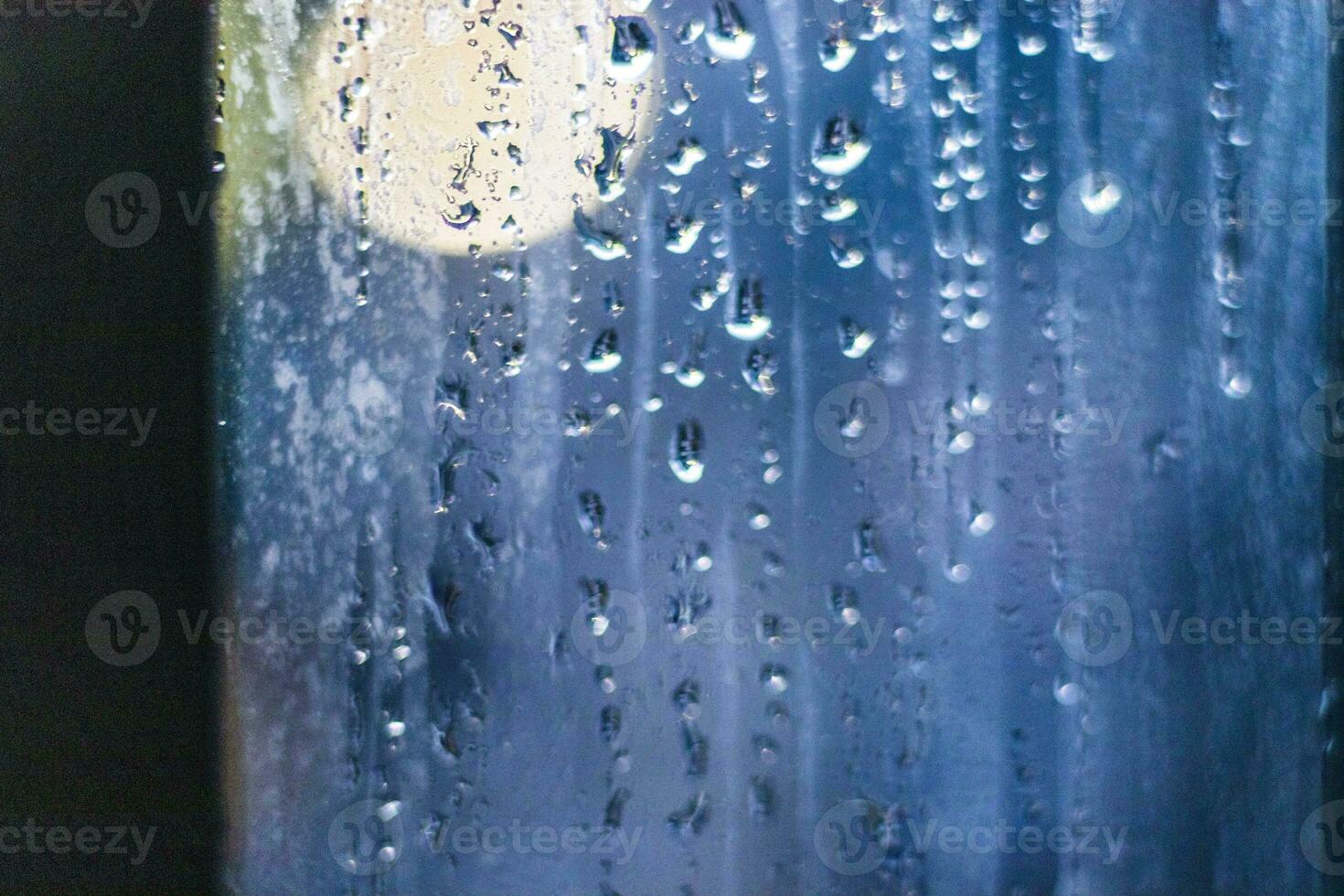 Shot of the window after rain with blurred lights on the background. Concept photo