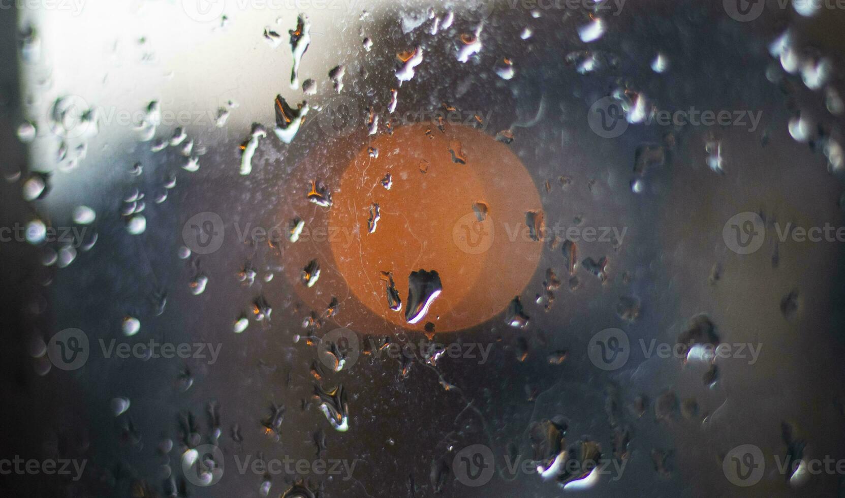 Shot of the window after rain with blurred lights on the background. Concept photo