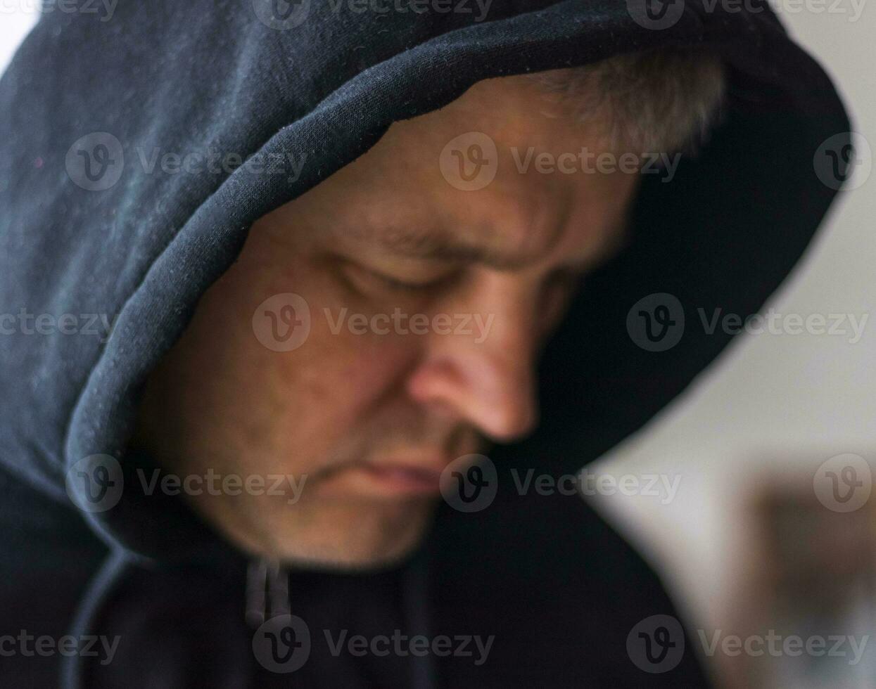 Man looked like hacker in a hood looking at the screen. People photo