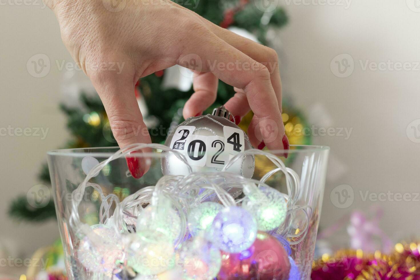 cerca arriba Disparo de mujer decorando Navidad árbol. nuevo año cambiando números. fiesta foto