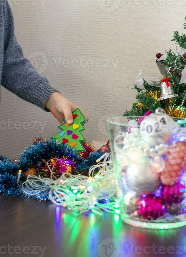 cerca arriba Disparo de nuevo año decoraciones pequeño chico decorando Navidad árbol. nuevo año cambiando números. fiesta foto